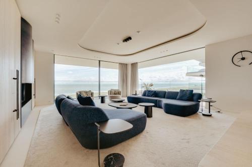 a living room with two blue couches and a table at Residence DeBlanke Top - 1D - Cadzand in Cadzand-Bad
