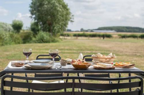 a table with plates of food and wine glasses at Gastenverblijf Begheynhof - your perfect escape in Biervliet