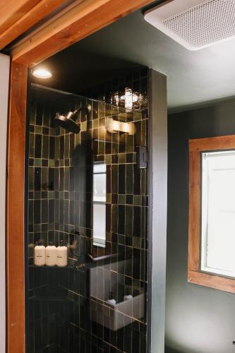 a bathroom with a black tiled wall at The Stranger Lodge - Pet Friendly in Sisters