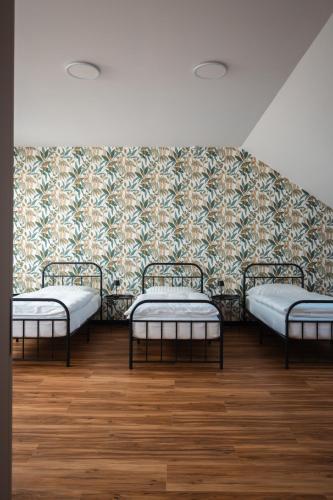 three beds in a room with a wall at Penzión ZAYDA in Výrava