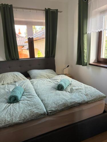 a bed with two towels on it with a window at Apartmán Madlen in Dolní Bobrová
