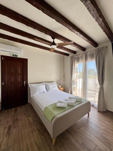 a bedroom with a bed and a large window at Anogeio in Afitos