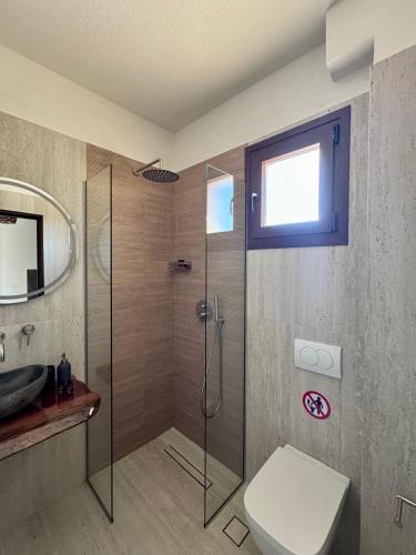 a bathroom with a shower with a toilet and a sink at Anogeio in Afitos