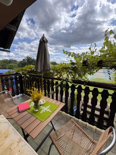 a balcony with a table and chairs and an umbrella at Weekendica in Fokovci
