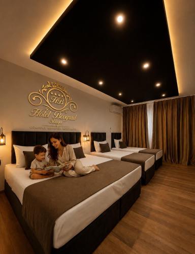 a woman and child sitting on beds in a hotel room at Hotel Beograd Struga in Struga
