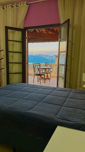 a bedroom with a bed and a view of the desert at Suíte privativa - Centro Guararema in Guararema