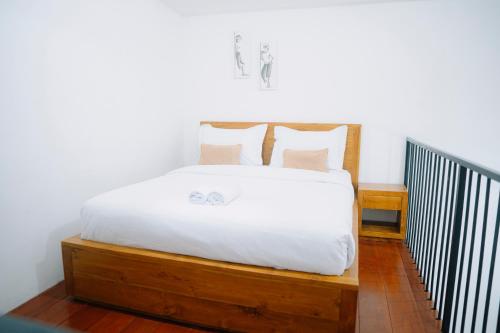 a bedroom with a bed with white sheets and pillows at D'Muarra Studio Villa in Cemagi
