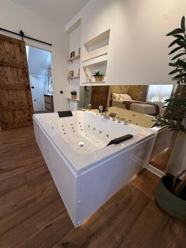 a large white bath tub in a room at La Flor in El Molar