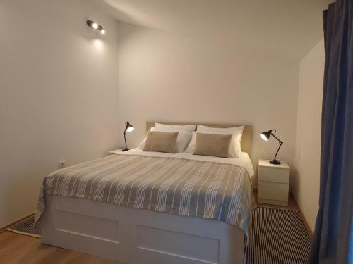 a bedroom with a bed with two lamps on it at Casa Colone in Bale