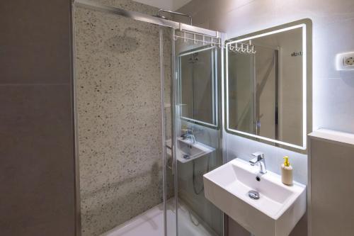 a bathroom with a sink and a glass shower at Apartments Marin in Podstrana