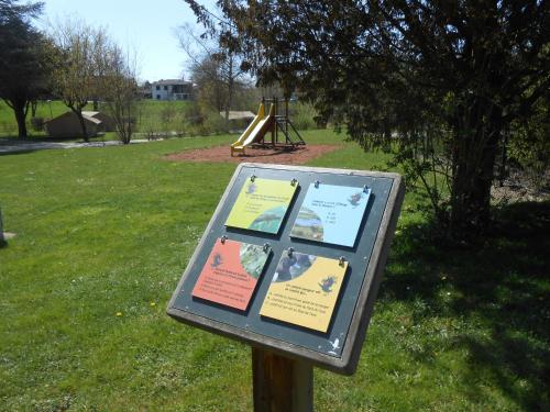a sign in a park with a playground at Camping le Nid du Parc in Villars-les-Dombes