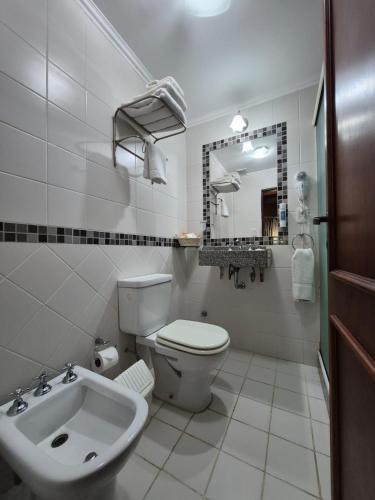 a white bathroom with a toilet and a sink at AGUAMARINA SPA Y APART in Formosa