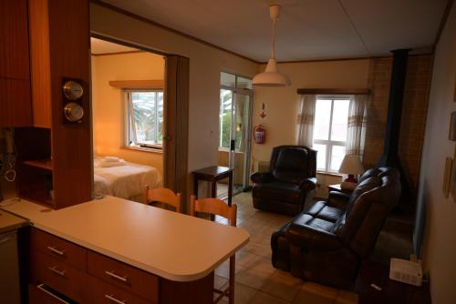 a living room with a room with a bed and a couch at Sleep to the Sound of Waves - Full Private Apartment in Swakopmund