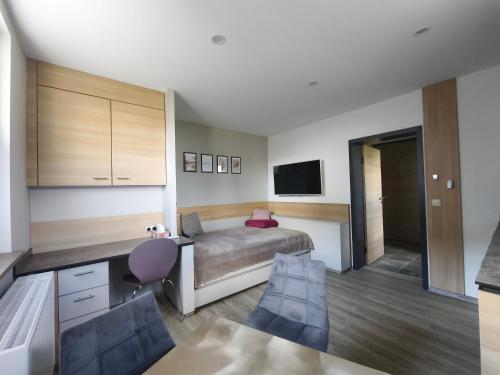 a bedroom with a bed and a table and chairs at Am Flutgraben in Adorf