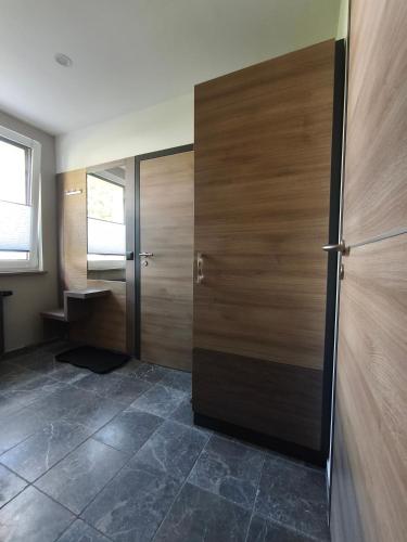 a room with two wooden doors and a tile floor at Am Flutgraben in Adorf