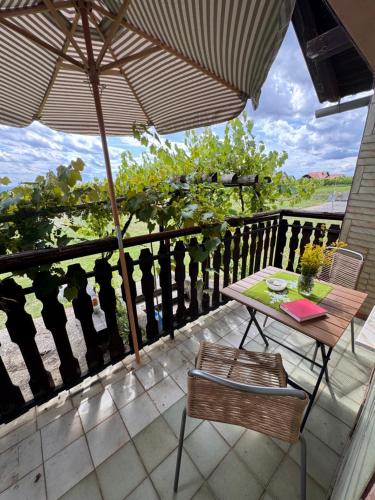 a table and chairs on a balcony with an umbrella at Weekendica in Fokovci