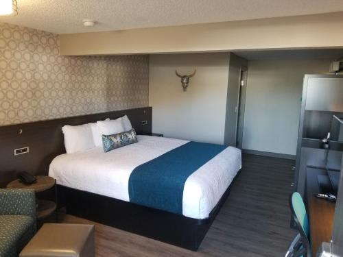 a hotel room with a large bed and a couch at The Hotel Y, a Dazzler Select by Wyndham in Yakima