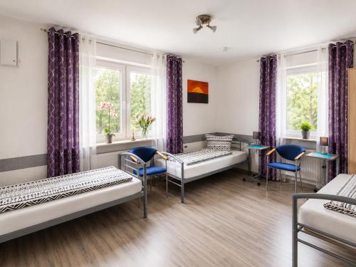 a room with beds and chairs and windows at Ferienhaus Bailey in Laupheim