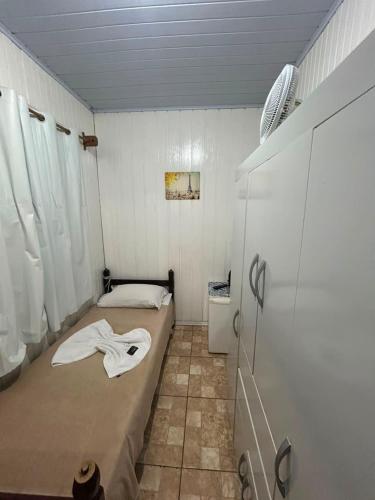 a small room with a bed and a shower at Pousada Tia Leonor in Gramado