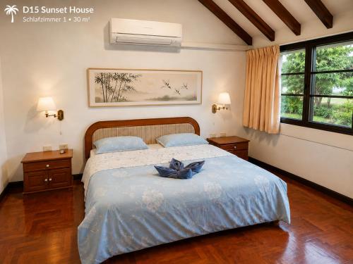 a bedroom with a bed with a blue bow on it at Oceanside Place in Rayong