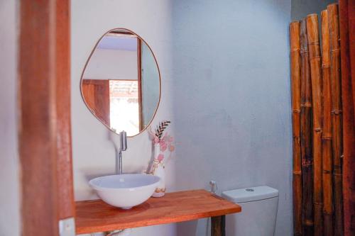 a bathroom with a bowl sink and a mirror at Pousada vila jaguar in Tutóia