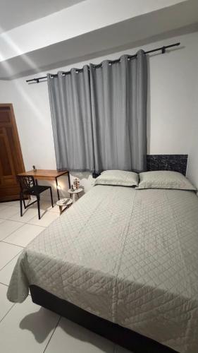 a bedroom with a large bed with a gray curtain at Sobrado Tropical a 1 Km da faculdade Unic e UFMT in Cuiabá