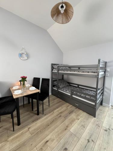 a room with a dining table and bunk beds at Sunbella Sarbinowo in Sarbinowo
