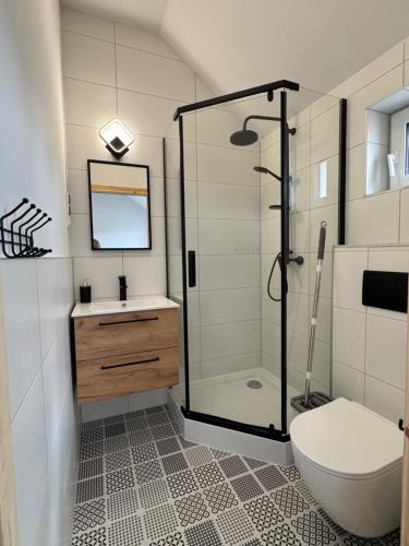 a bathroom with a shower and a toilet and a sink at Sunbella Sarbinowo in Sarbinowo