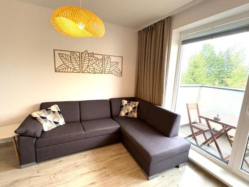 a living room with a couch and a large window at Apartmán pod Rovencom in Nové Mesto nad Váhom
