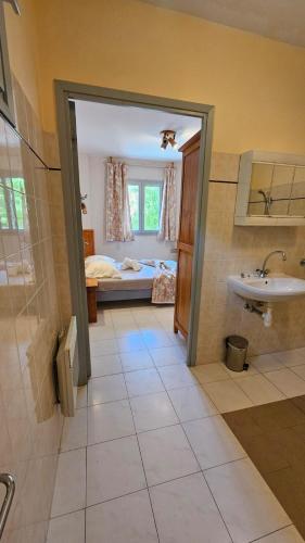 a bathroom with a sink and a bedroom with a bed at Auberge du Coustet in Saint-Léger