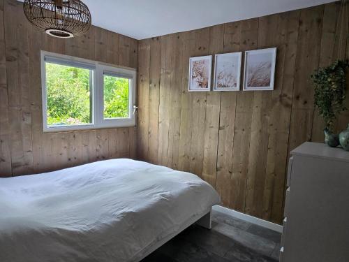 a bedroom with wood paneled walls and a bed at Scandinavian Forest Cabin in Twente in Markelo