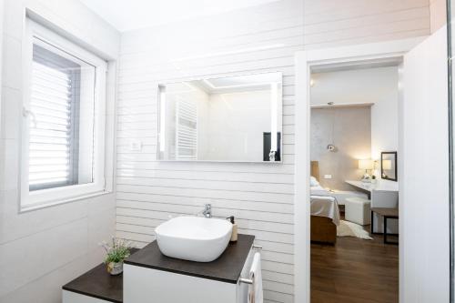 a white bathroom with a sink and a mirror at Island Breeze Oasis by Belmont Realty in Vela Luka