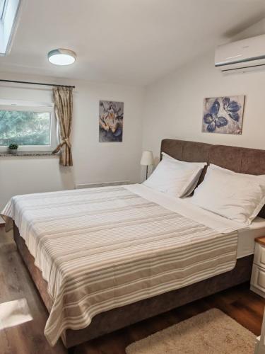 a large bed in a room with a window at AdisiTi S2 in Zagreb