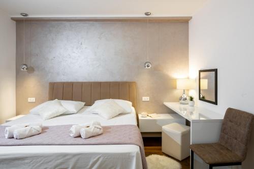 a bedroom with a bed and a desk and a chair at Island Breeze Oasis by Belmont Realty in Vela Luka