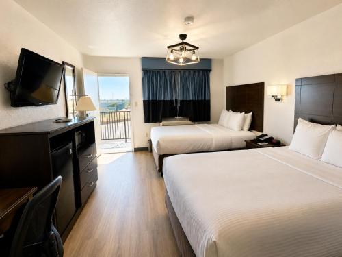 a hotel room with two beds and a flat screen tv at Quality Inn Parker in Parker