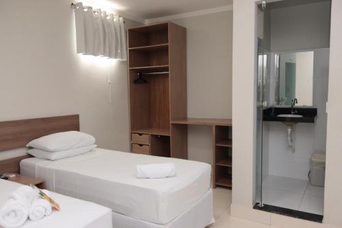 a small bathroom with two beds and a sink at Hotel Macapaba in Macapá