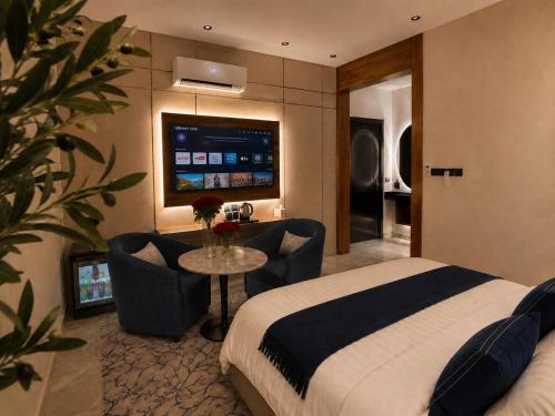 a hotel room with a bed and a table and chairs at Toot Suites Studio in Abha