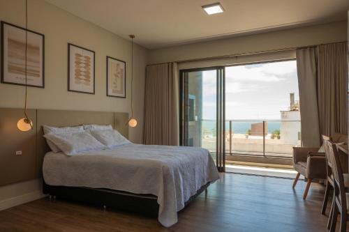 a bedroom with a bed and a large window at Villa Francione in Bombinhas
