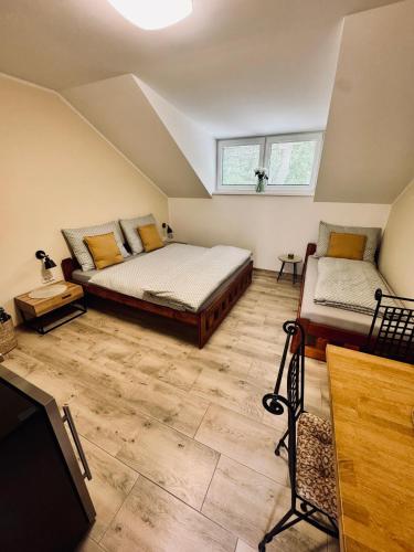 a attic bedroom with two beds and a tv at Ubytování U Špíšků in Jaroslavice