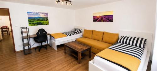 a room with a couch and a bed and a desk at Klidná Chalupa in Bulhary