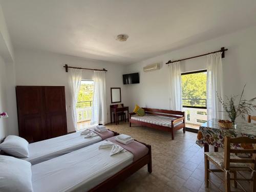 a bedroom with two beds and a living room at Zourpos Studios in Kalyves