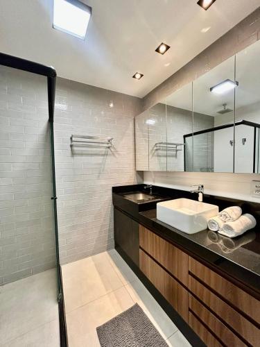a bathroom with a sink and a mirror at Vista Ampla e Estilo Industrial nesse Lindo Loft in Campo Grande