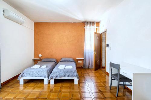 a bedroom with two beds and a desk at Via Gagliardi - Centro in Vibo Valentia