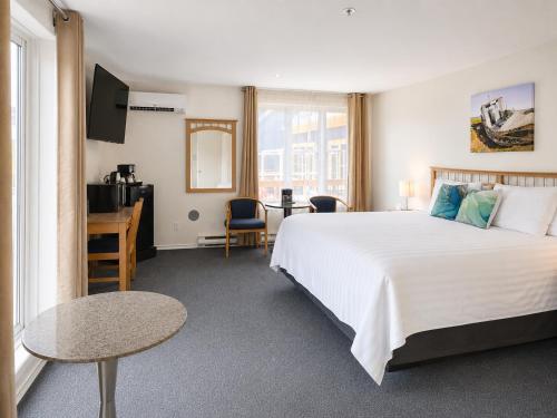 a hotel room with a large bed and a desk at Rum Runner Inn in Lunenburg