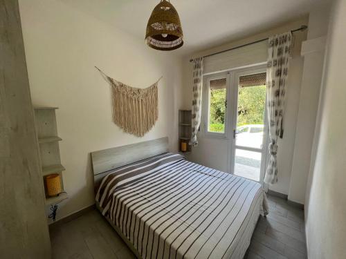 una camera da letto con un letto e una finestra e una finestra di Appartamento Il Garofano a Quercianella