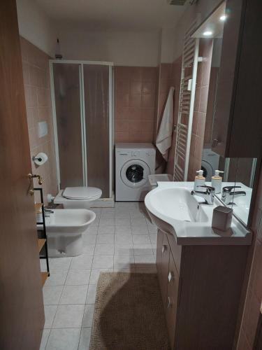 a bathroom with a sink and a toilet and a washing machine at Brilu in Savona