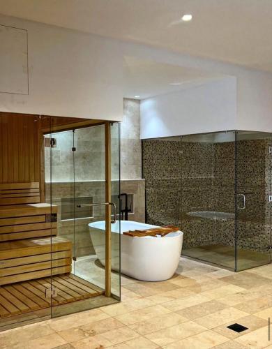 a large bathroom with a tub and a shower at The W Luxury Chalet in Salalah