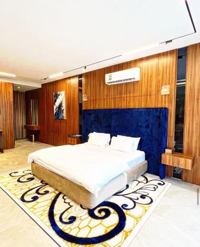 a bedroom with a large bed with a blue wall at The W Luxury Chalet in Salalah