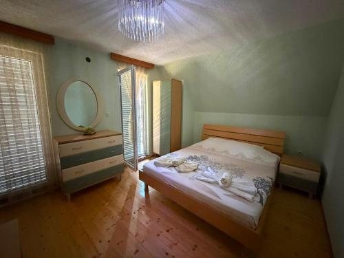 a bedroom with a bed with a mirror and a dresser at Villa Tara in Gostivar