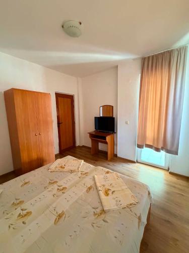 a bedroom with a bed with paper on it at Guest House Dayana Apartment 2 in Ravda